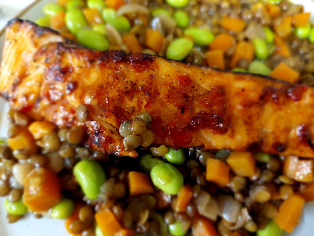 Salmon Filet topped with Tomato & Chilli Jam served on a bed of Green Lentils with vegetables